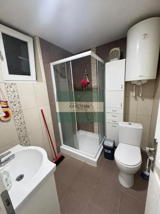 Bathroom equipped with a shower cabin, washbasin, toilet, and water heater.