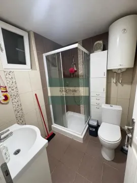 Bathroom equipped with a shower cabin, washbasin, toilet, and water heater. - image 5