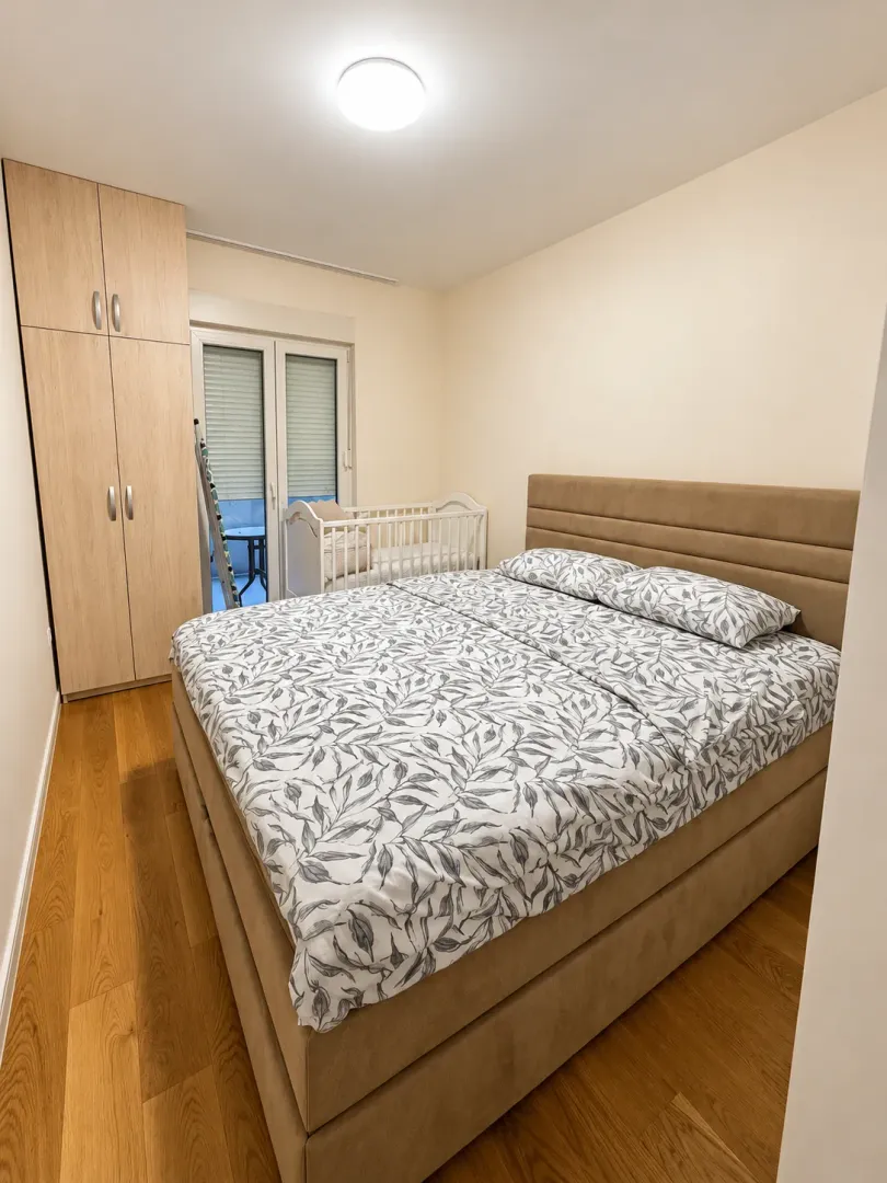 Bedroom with a double bed, wardrobe, and baby crib.