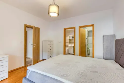 Spacious bedroom with a double bed and a view of doors leading to the bathroom and other rooms. - image 7