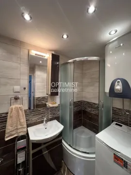 Bathroom with a shower cabin, washbasin, and water heater. - image 7