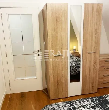 Bedroom with a wooden wardrobe, mirror, and white door. - image 4