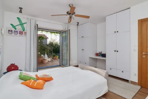 Bright bedroom with a double bed, white wardrobes, and access to the terrace. - image 7