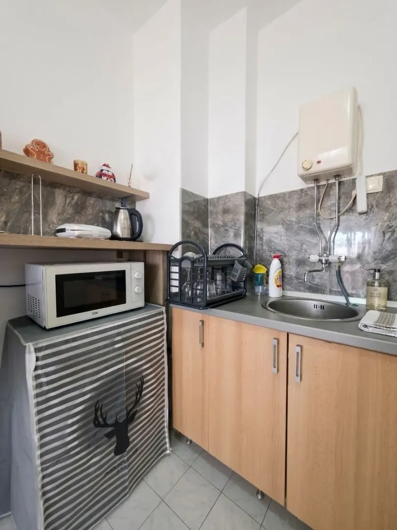 Small kitchen with a sink, kitchen units, and a microwave.