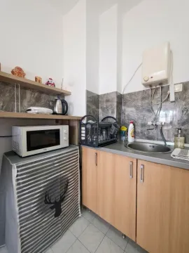 Small kitchen with a sink, kitchen units, and a microwave. - image 3