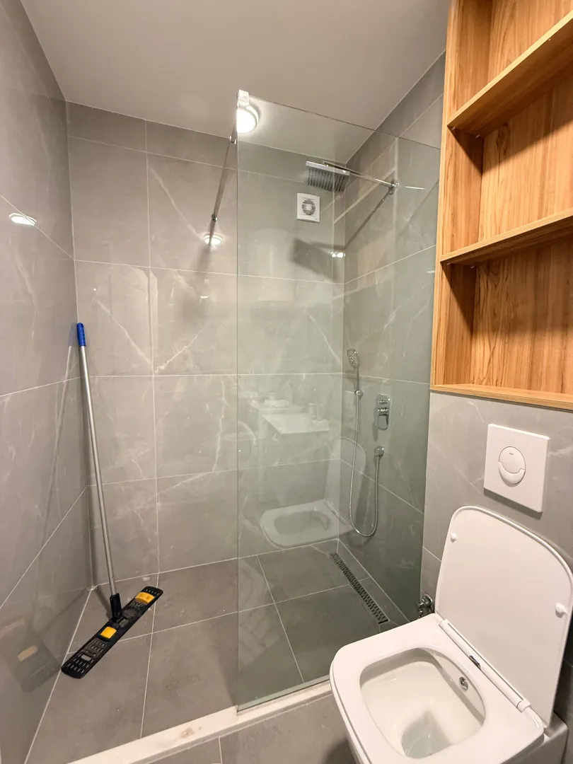 Moderne kupatilo sa tuš kabinom i ugradnim wc šoljom.