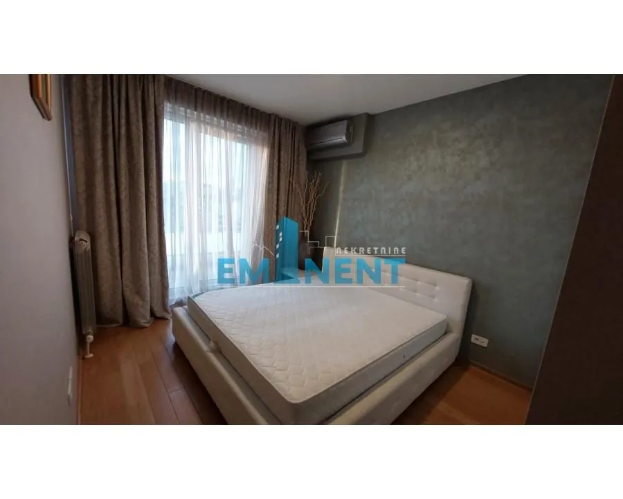 Bedroom with a double bed and a window with curtains.