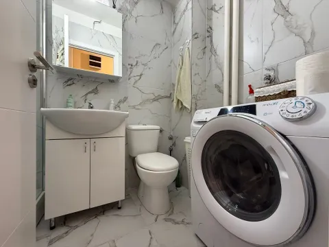 Kupatilo opremljeno umivaonikom, WC šoljom i veš mašinom. - image 15