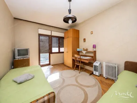 Namještena spavaća soba sa dva kreveta, radnim stolom i balkonskim vratima. - image 12