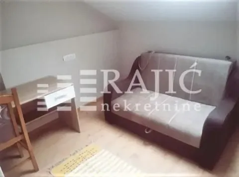 Smaller bedroom with a pull-out sofa and a desk. - image 7