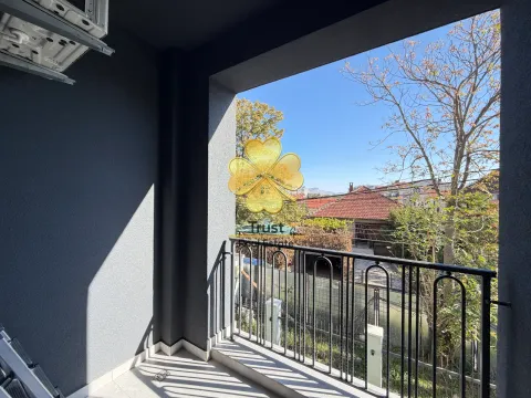 Natkrivena terasa sa crnom ogradom i pogledom na okolno naselje. - image 4