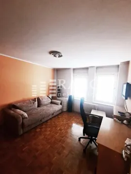 Living room with a sofa, desk, and parquet flooring. - image 4
