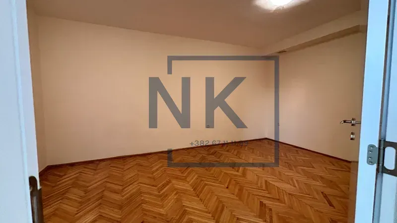 Empty room with parquet flooring and white walls.