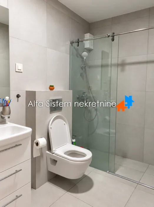 Savremeno opremljeno kupatilo sa tuš kabinom i ugradnom sanitarijom.