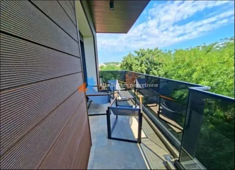 Furnished balcony space with green views and glass railing. - image 4