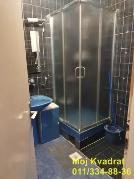 Bathroom with a shower cabin, washbasin, and dark tiles. - image 9