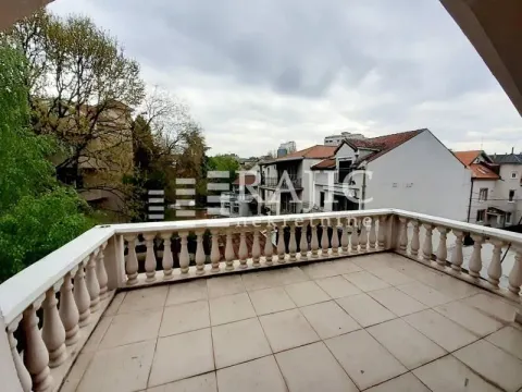 Spacious terrace with stone railing and city view. - image 3