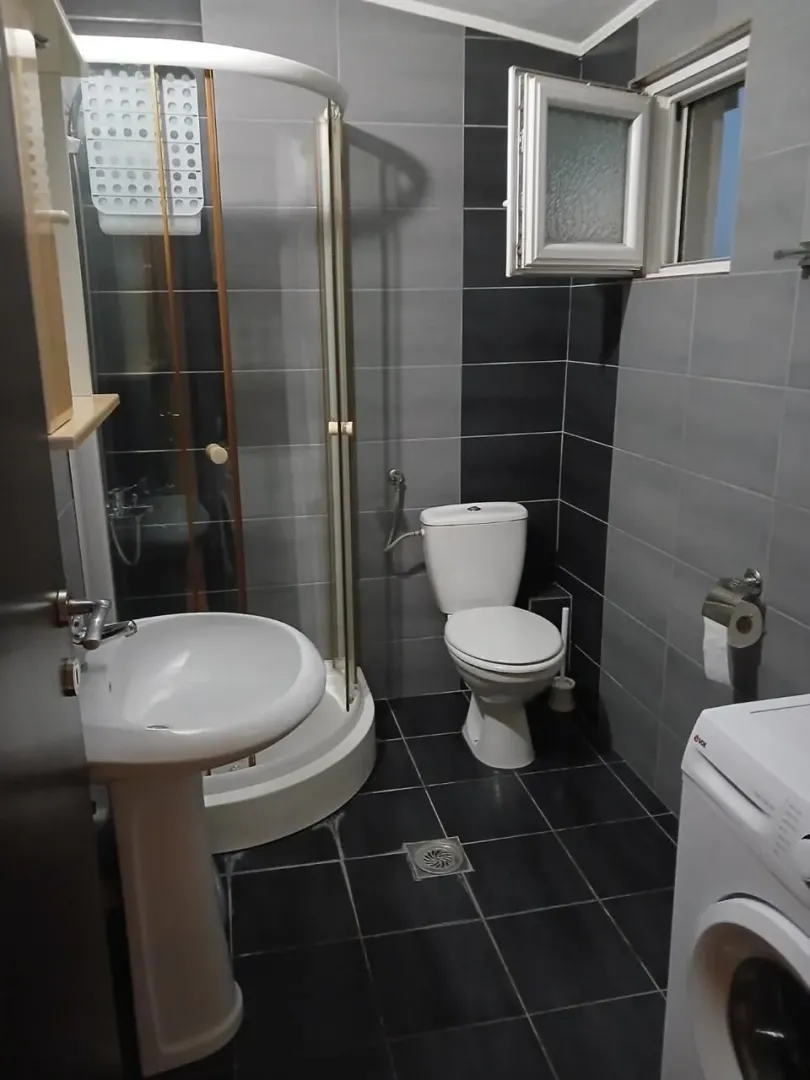 Kupatilo sa tuš kabinom, umivaonikom, WC šoljom i veš mašinom.