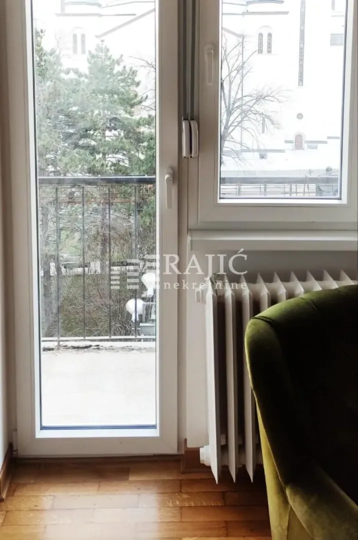 View of the terrace and part of the living room with a green armchair.