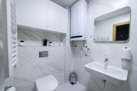 Moderno opremljeno kupatilo sa bijelim pločicama i tuš kabinom. - image 6