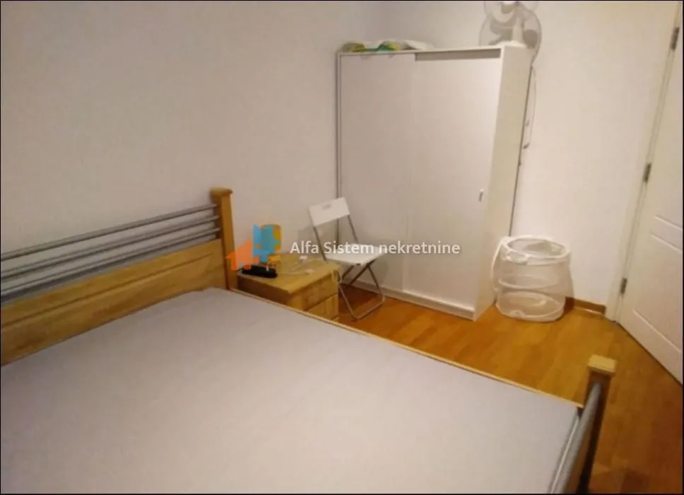 Bedroom with a double bed, wardrobe, and wooden flooring.
