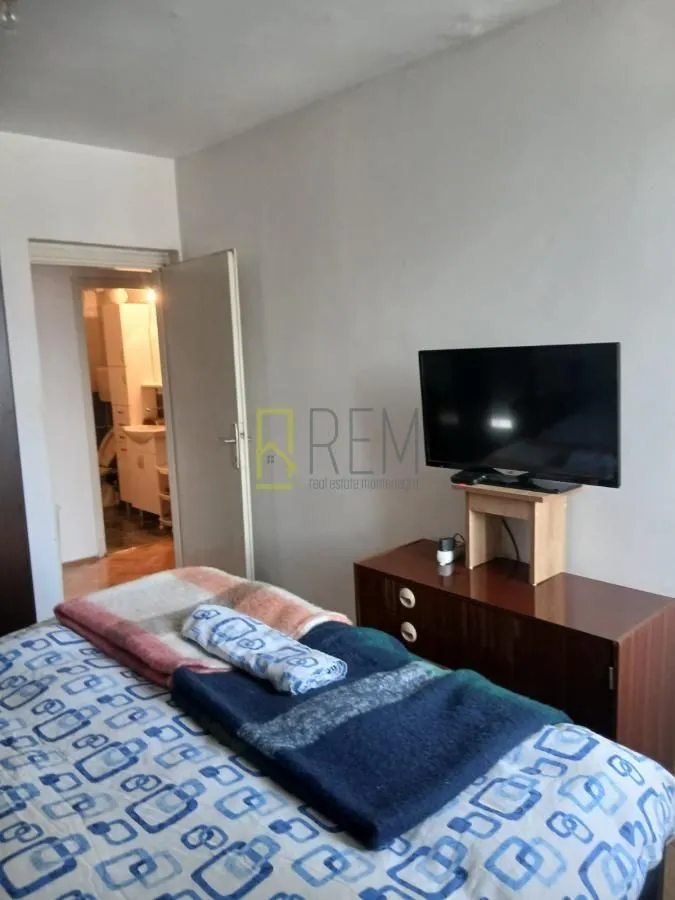 Bedroom with a bed, dresser, and television.