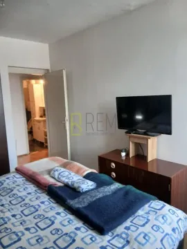 Bedroom with a bed, dresser, and television. - image 7