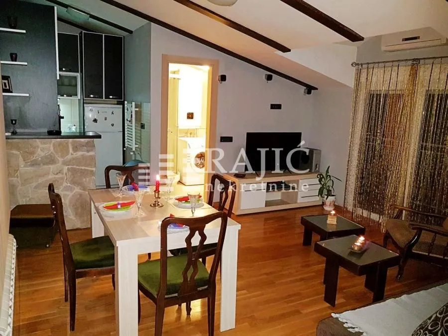 Living room with dining area and view of the kitchen and bathroom.