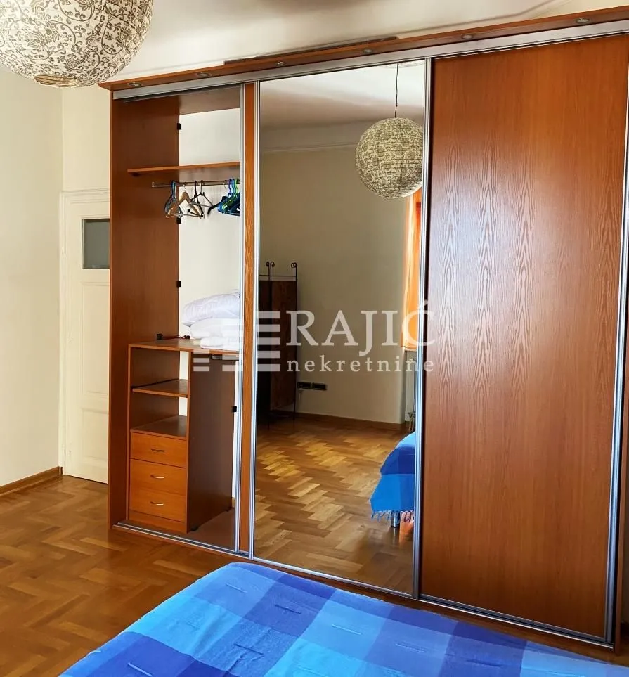 Bedroom with a large wooden wardrobe featuring a mirror.