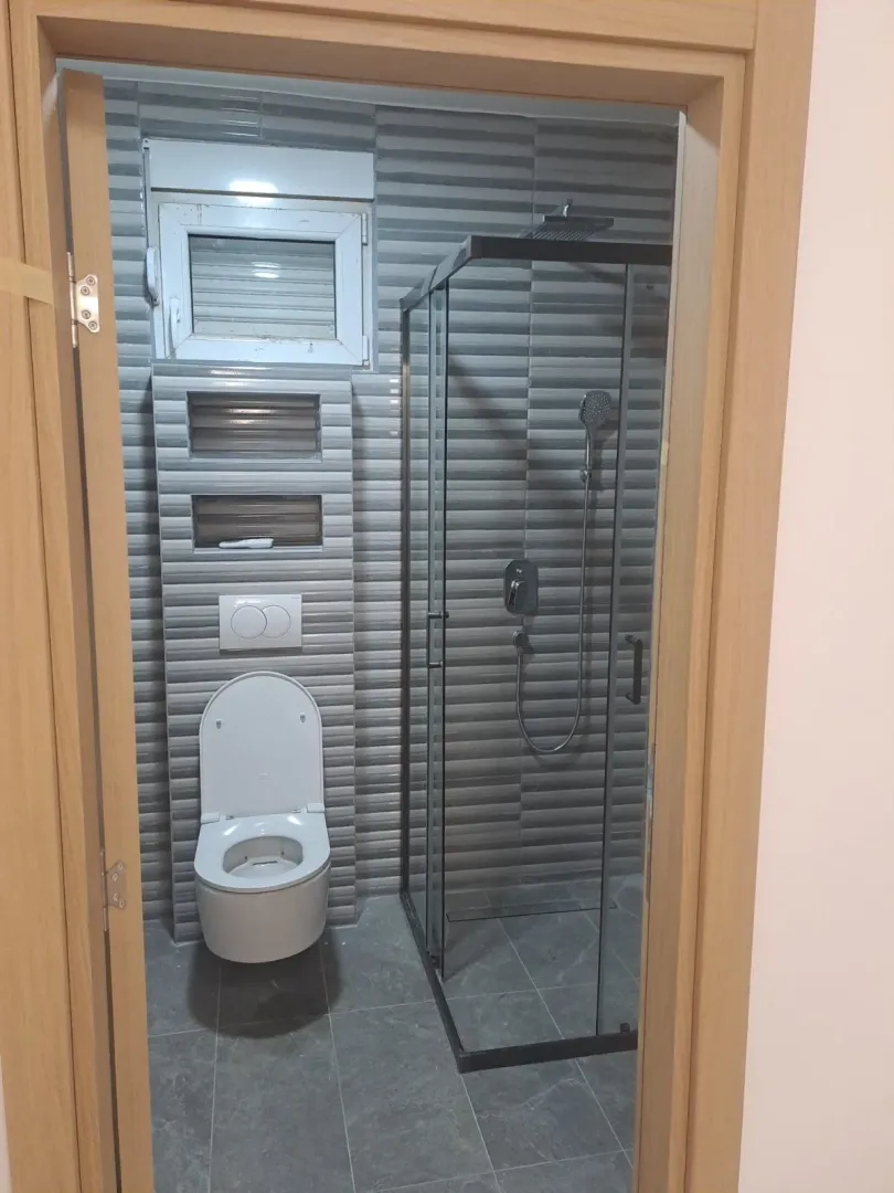 View through the doorway into a modern bathroom equipped with a shower cabin.