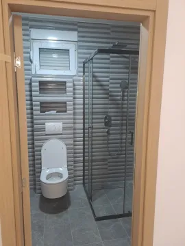 View through the doorway into a modern bathroom equipped with a shower cabin. - image 7
