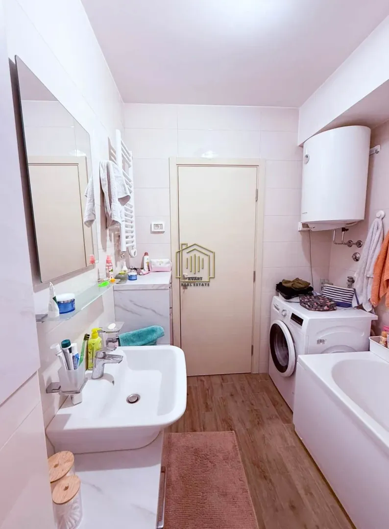 Bathroom equipped with a washbasin, bathtub, washing machine, and water heater.