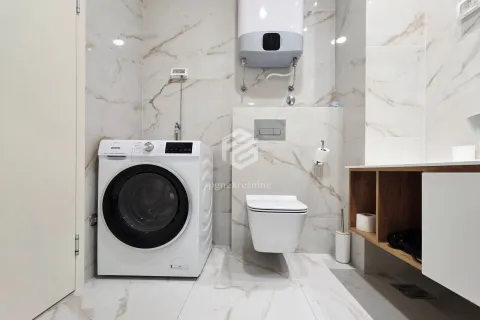 Bathroom with a washing machine, wall-hung toilet, and water heater. - image 14