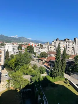 Pogled sa prozora na gradski pejzaž i okolne planine. - image 14