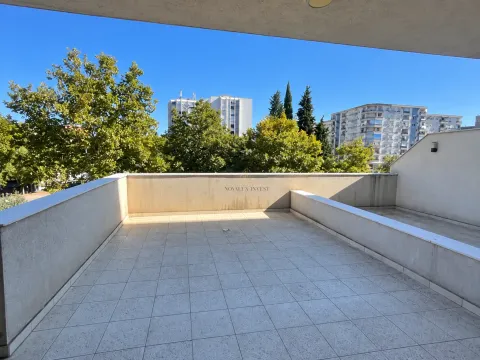 Spacious tiled terrace with a view of the city and greenery. - image 3