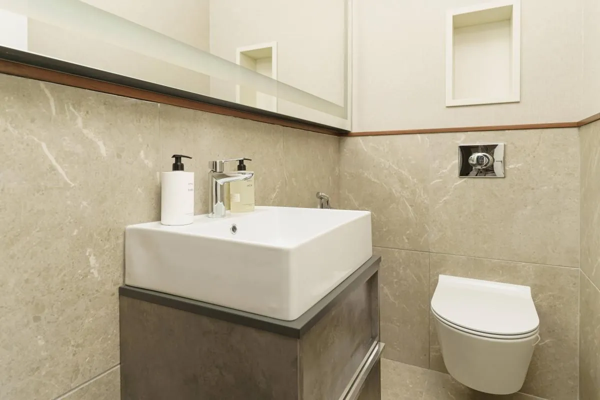 Moderno kupatilo sa bijelim lavaboom i konzolnom wc šoljom.