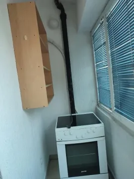 An enclosed terrace featuring an electric stove and a wall shelf. - image 8
