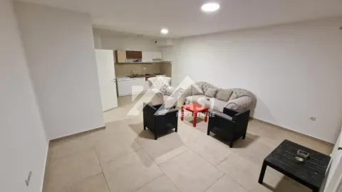 Dnevni boravak sa garniturom i kuhinjom u pozadini. - image 3