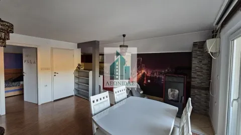 Living room with a dining area, pellet stove, and a view of the kitchen. - image 3