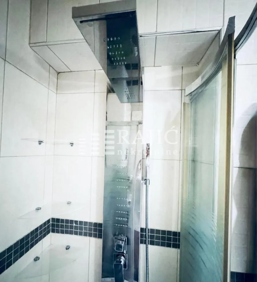 View of a shower cabin with a hydromassage column in the bathroom.