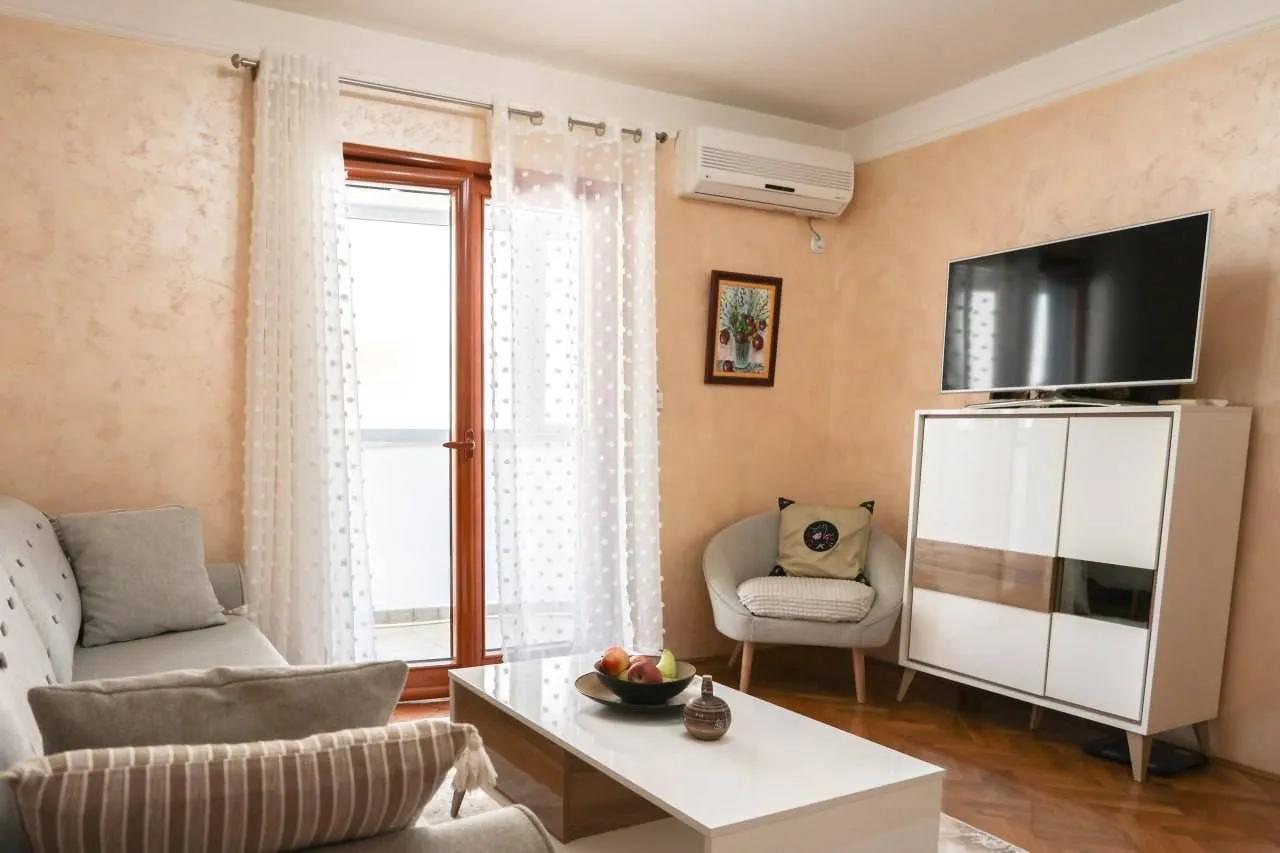 Living room with a sofa, TV cabinet, and access to the terrace.