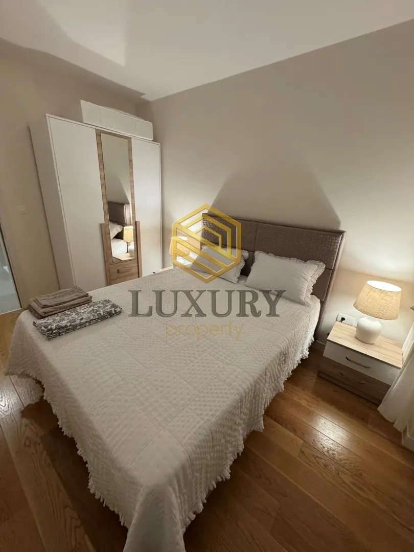 Furnished bedroom with a double bed, wardrobe, and a nightstand.