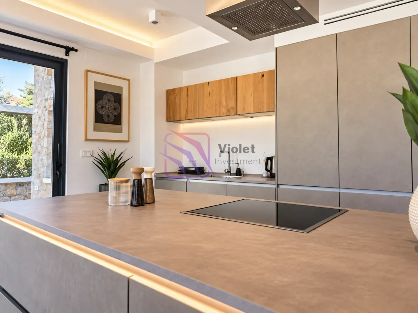 Modern kitchen with an island, built-in cooktop, and wooden cabinetry.