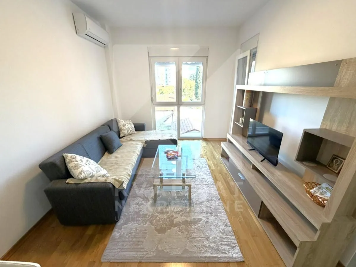 Living room with sofa, TV unit and access to the terrace.