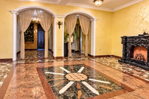 Spacious living room with a decorative fireplace, ornamental pillars, and a marble floor. - image 4