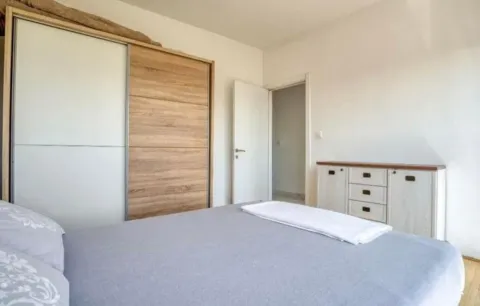 Bedroom with a large double bed, wardrobe, and chest of drawers. - image 3