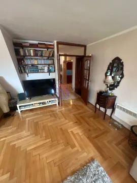Dnevna soba sa drvenim parketom, televizorom i policom za knjige. - image 10