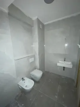 Manje kupatilo obloženo sivim pločicama sa sanitarijama. - image 9