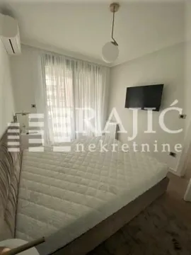 Bedroom with a double bed, TV, and access to the terrace. - image 4