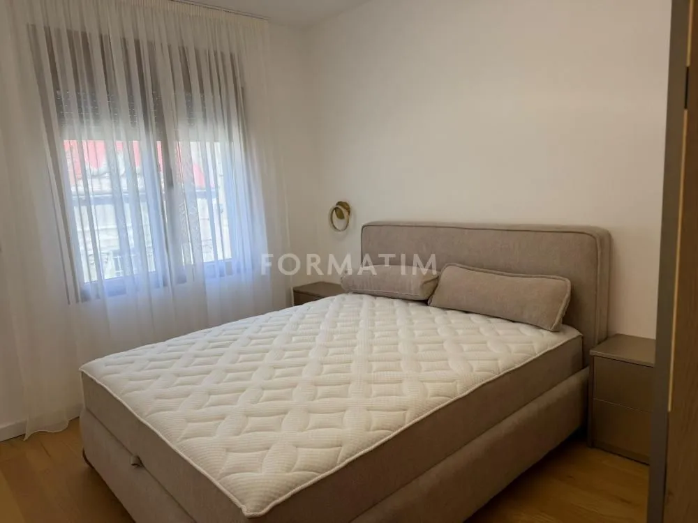 Bedroom with a double bed and a window with curtains.
